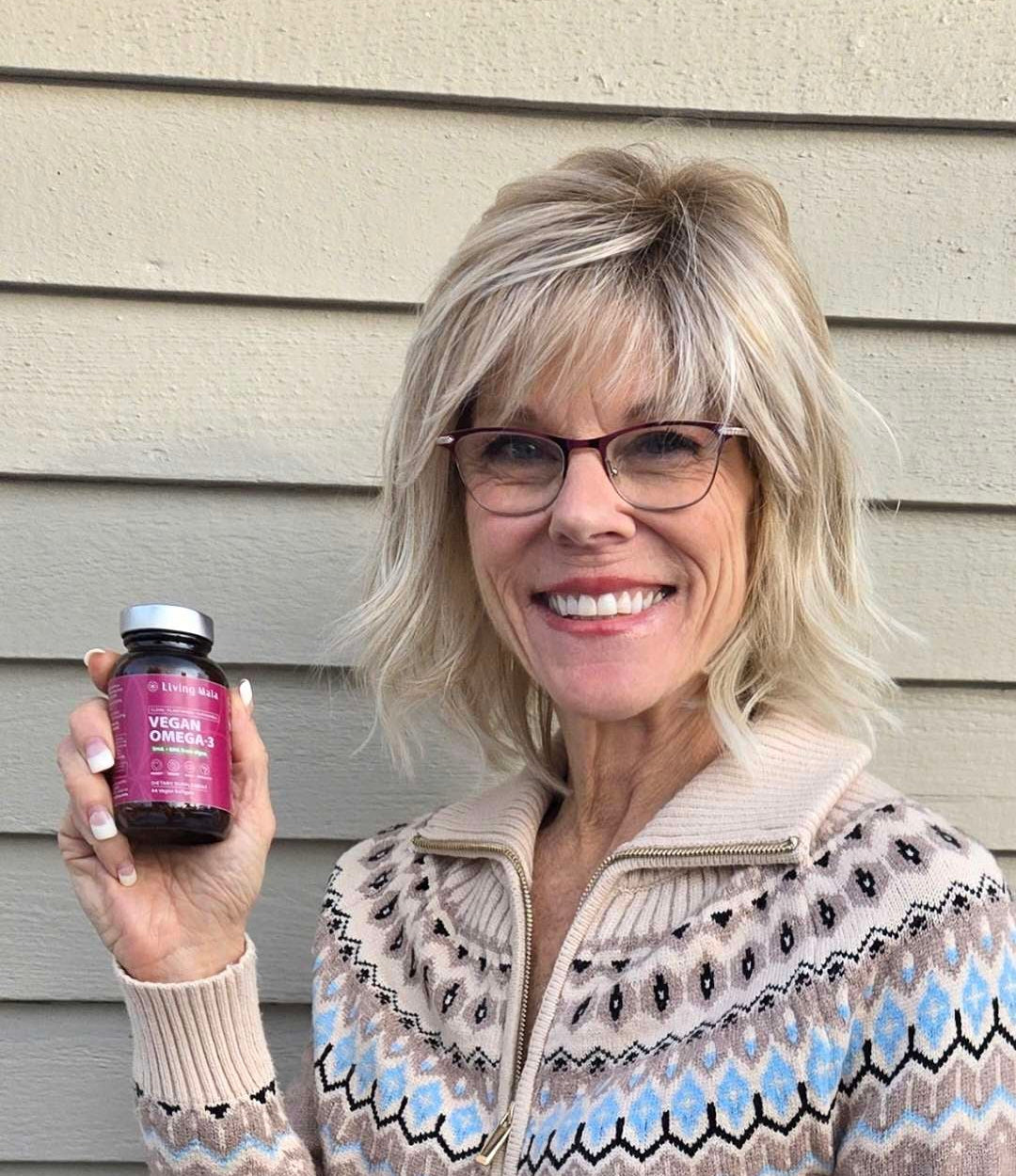 Customer Christina holding Living Maia vegan omega-3 supplement bottle