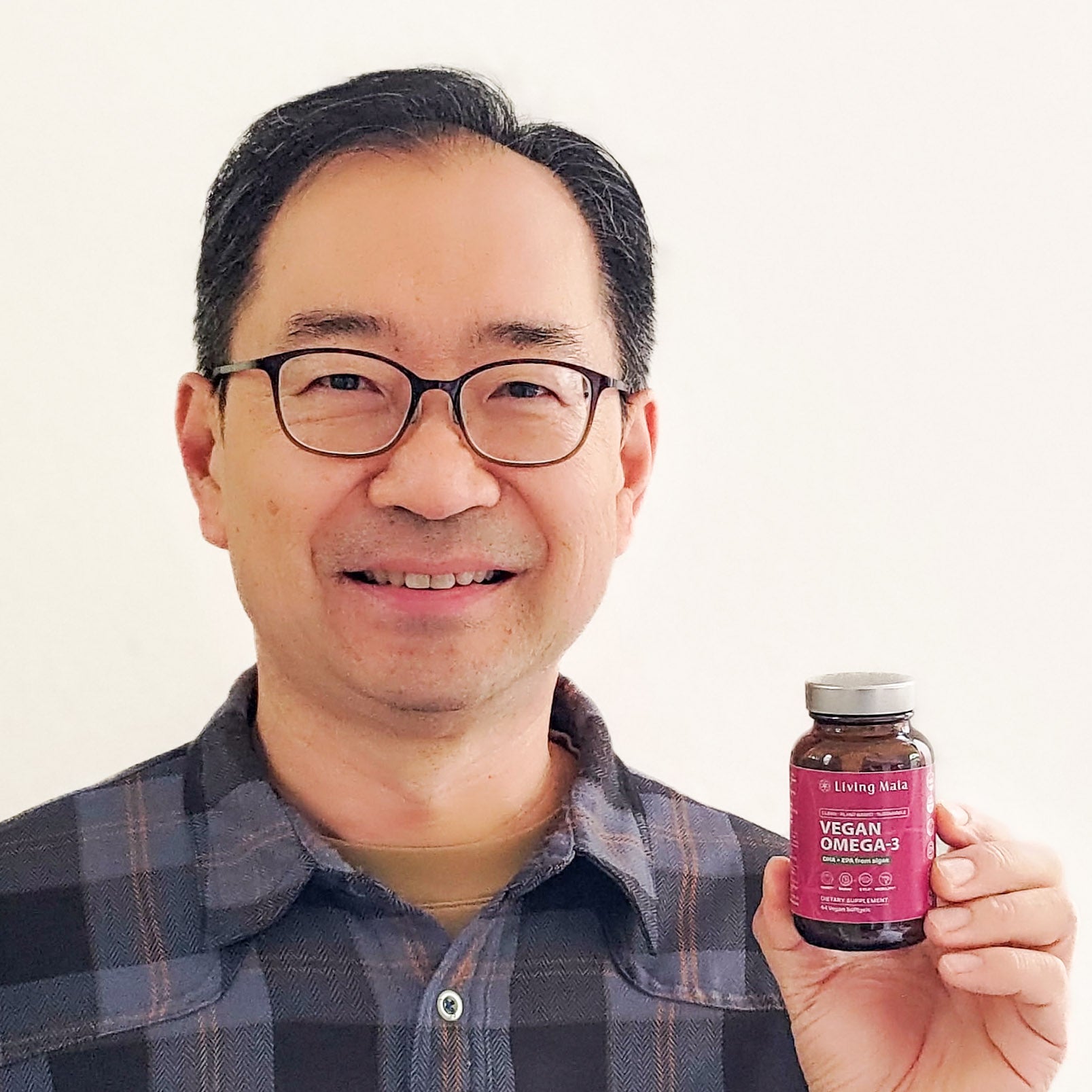 Customer Tim holding Living Maia vegan omega-3 supplement bottle