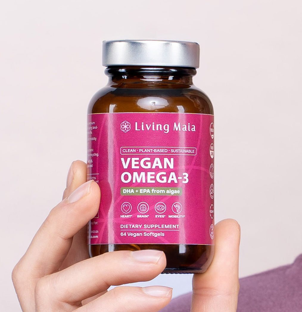 Living Maia Vegan Omega-3 algae softgel supplement bottle held in hand