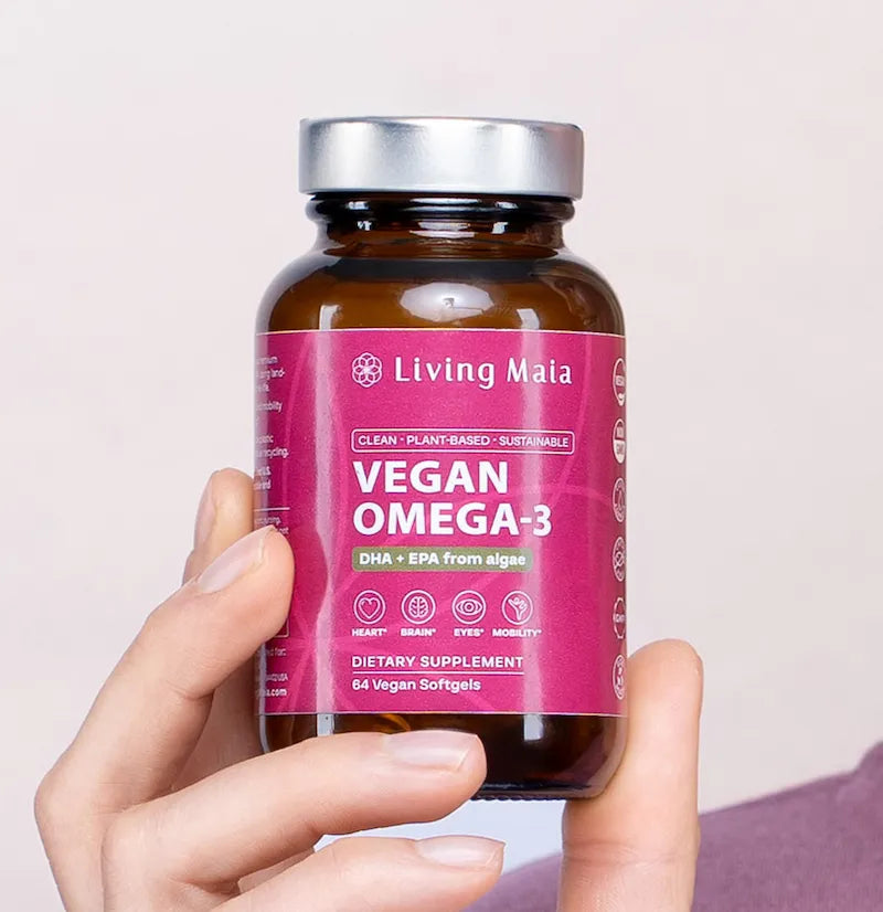 Living Maia Vegan Omega-3 algae softgel supplement bottle held in hand