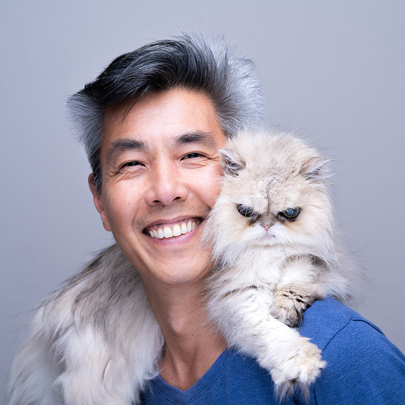 Su Ruan, founder of Living Maia, smiling while holding his cat